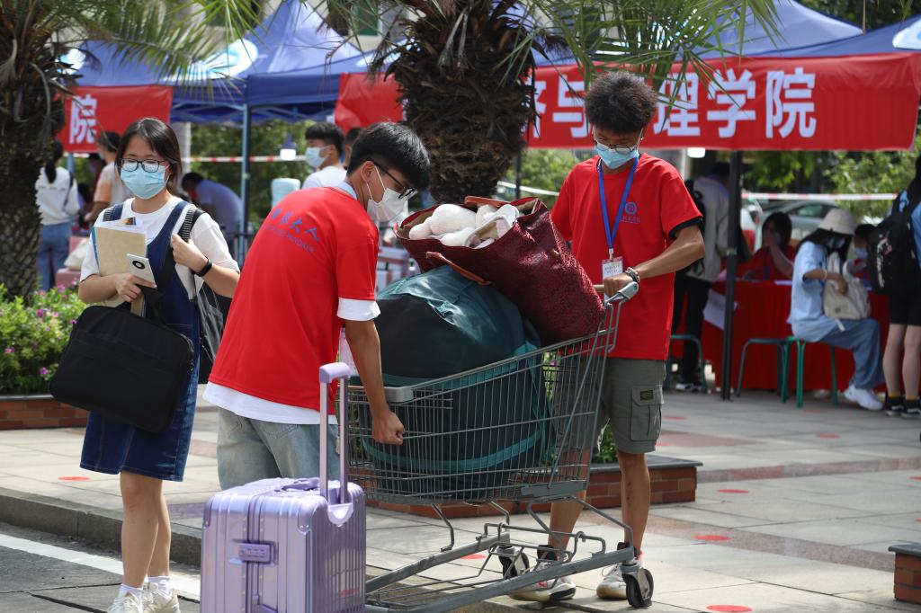 志愿者帮新攀豆儿搬运行李